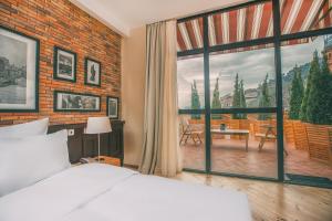 a bedroom with a bed and a large window at Kisi Boutique Hotel in Tbilisi City