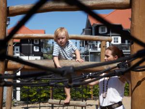 two young boys are playing on a playground at 5 person holiday park in Bogense in Bogense