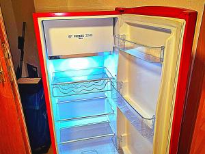 an empty refrigerator with its door open in a kitchen at Ferien & Monteure Residence in Schauenburg