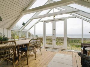 a conservatory with a table and chairs and windows at 4 star holiday home in Asnæs in Asnæs