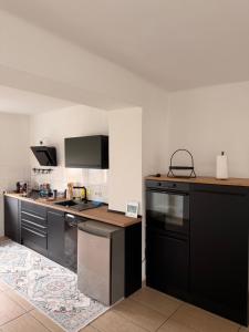 a kitchen with black cabinets and a counter top at Appartement Heidstock in Völklingen