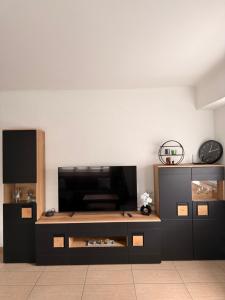 a living room with a entertainment center with a flat screen tv at Appartement Heidstock in Völklingen