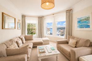 a living room with two couches and a table at The Old Post Office - Parking Available - 75 meters Estuary in Salcombe