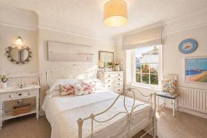 a white bedroom with a bed and a sink at The Old Post Office - Parking Available - 75 meters Estuary in Salcombe +15 photos