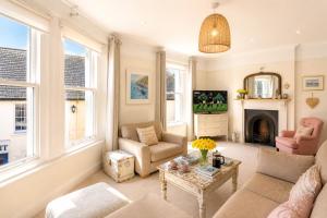 a living room with a couch and chairs and a fireplace at The Old Post Office - Parking Available - 75 meters Estuary in Salcombe
