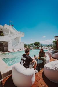 a group of people sitting around a swimming pool at Villa JOSANA in Sarandë