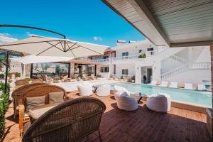 an outdoor patio with a pool and chairs and an umbrella at Villa JOSANA in Sarandë