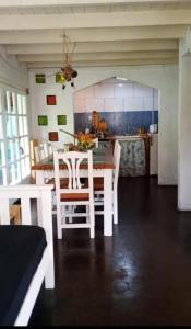 a kitchen with a table and chairs in a room at Chalet para 7 en Mar del Plata con parque y parrilla in Mar del Plata