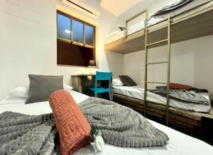 a bedroom with two bunk beds and a blue chair at Unidade 2 - GoHost Suítes in Ribeirão Preto