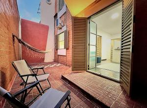 a patio with two chairs and a glass door at Unidade 2 - GoHost Suítes in Ribeirão Preto