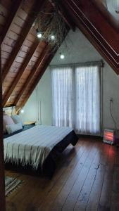 a bedroom with a bed and a large window at Chalet para 7 en Mar del Plata con parque y parrilla in Mar del Plata