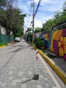 an empty street with a wall with graffiti at SWELL house, EL TUNCO in El Sunzal +5 photos