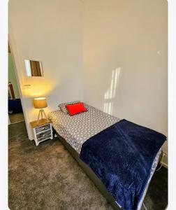 a bedroom with a bed with a red pillow on it at Euro Nomads in Melbourne