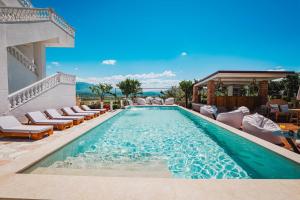 a swimming pool with chaise lounge chairs and a resort at Villa JOSANA in Sarandë