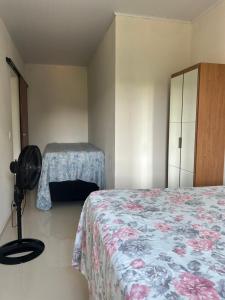 a bedroom with two beds and a dresser and a bed at Maria Luiza da silva in Japaratinga
