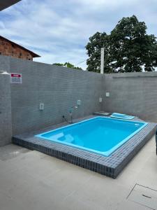 a large blue swimming pool in a brick wall at Maria Luiza da silva in Japaratinga +2 photos