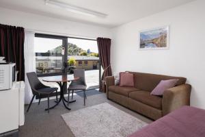a living room with a couch and a table at Harbour View Motel in Picton