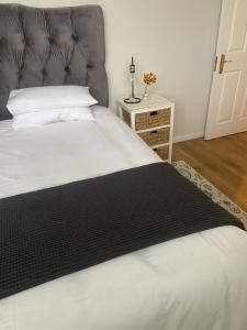 a bedroom with a large bed with a black headboard at Railway Cottage at Rawdons Country Estate in Nottingham Road