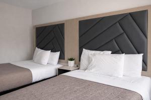 two beds sitting next to each other in a hotel room at Fair Motel in Upper Saddle River