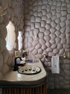 a bathroom with a sink and a stone wall at Hotel Budamar Zipolite in Zipolite