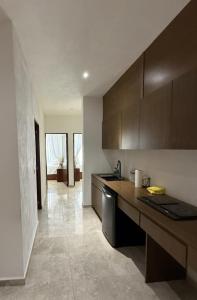a kitchen with brown cabinets and a counter top at Apartamento en Punta Mita in Higuera Blanca