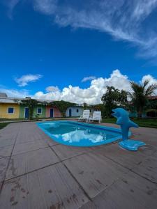 a dolphin statue next to a swimming pool at Pousada Villa Japa in Maragogi