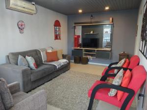 a living room with a couch and a tv at Apartamento London - Centro Nova Petrópolis in Nova Petrópolis