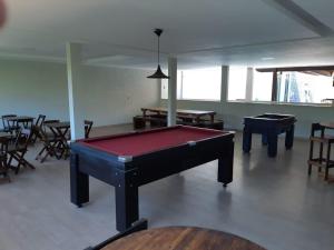 a pool table in a room with tables and chairs at Recanto do Galo in Volta Redonda