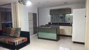 a kitchen with a counter and a couch in a room at Recanto do Galo in Volta Redonda