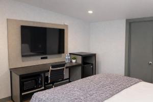 a hotel room with a bed and a flat screen tv at Fair Motel in Upper Saddle River