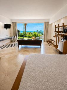 a large living room with a couch and a large window at Hotel La Mariposa in Manuel Antonio