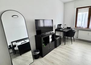 a living room with a mirror and a tv and a table at PW38 Studio Koblenz in Koblenz