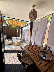 a patio with a wooden table and chairs on a deck at Stylish beach house in Privlaka in Privlaka
