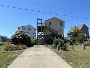 a house with a staircase on the side of a road at SOUTHERN STAR cottage in Hatteras