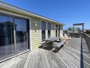 a wooden deck with a bench and a picnic table at SOUTHERN STAR cottage in Hatteras