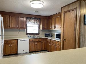a kitchen with wooden cabinets and a white dishwasher at SOUTHERN STAR cottage in Hatteras