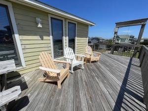 two chairs and a table on the deck of a house at SOUTHERN STAR cottage in Hatteras
