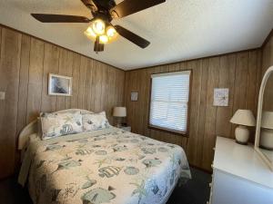 a bedroom with a bed and a ceiling fan at SOUTHERN STAR cottage in Hatteras +18 photos