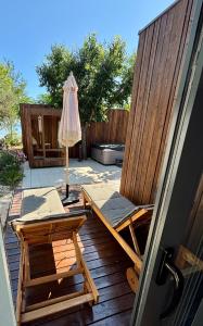 a patio with a chair and an umbrella on a deck at Stylish beach house in Privlaka in Privlaka