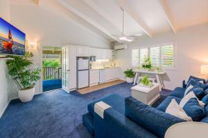 a living room with a blue couch and a kitchen at Debbie's Place in Rainbow Beach