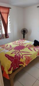 a bed with a colorful blanket on top of it at Heaiti Lodge in Avatoru +10 photos