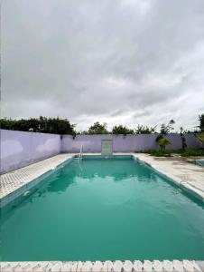 a large swimming pool with blue water at Mir's Farm House in Hyderabad