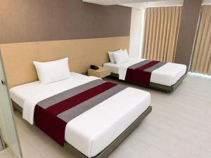 two beds in a hotel room with two beds at The E-Hotel Makati in Manila