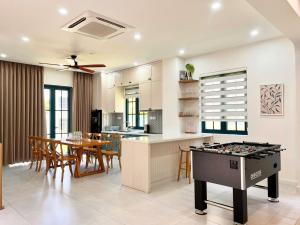 a kitchen and dining room with a ping pong table at Solara Coast Villa in Tiến Thành