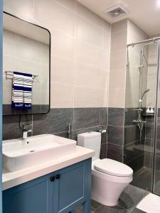 a bathroom with a sink and a toilet and a mirror at Solara Coast Villa in Tiến Thành +26 photos