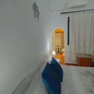 a bedroom with a white bed with blue pillows at ALBORADA TRES in Burguillos