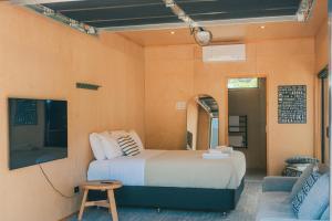 a bedroom with a bed and a couch at Wavesong Oceans 11, Onetangi - Be My Guest Waiheke in Waiheke Island