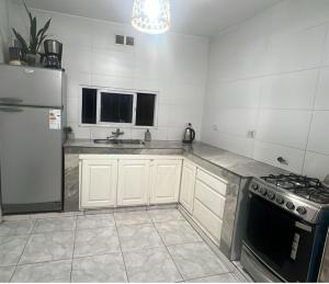 a kitchen with white cabinets and a stainless steel refrigerator at La Esperanza in Deán Funes