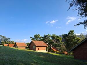 a group of houses on a grassy hill at Pousada Ecológica Rio do Peixe in Socorro