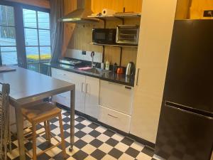 a kitchen with a table and a black refrigerator at The Windsor Suite in New Plymouth